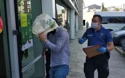 AVM’den hırsızlık zanlısı, adliyeye çıkarılırken tanınmamak için kafasına bez çanta geçirdi
