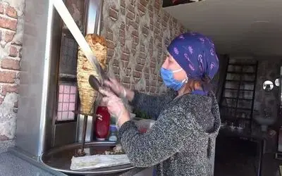 Kadın döner ustası parmakları yediriyor
