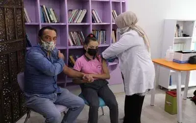 Veliler ve çocukları el ele korona aşısı oldu
