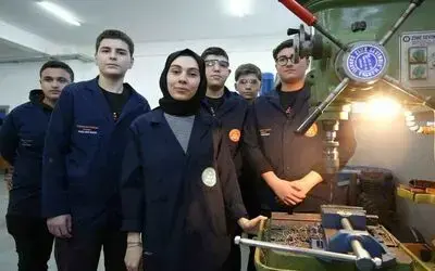 Kadın öğretmen torna tezgahında öğrencilerine üretimi öğretiyor
